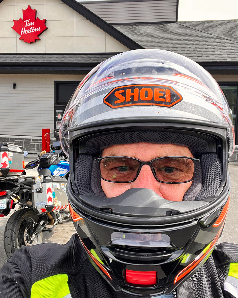 Me in motorcycle helmet, stopped at Timmy's, somewhere in BC.